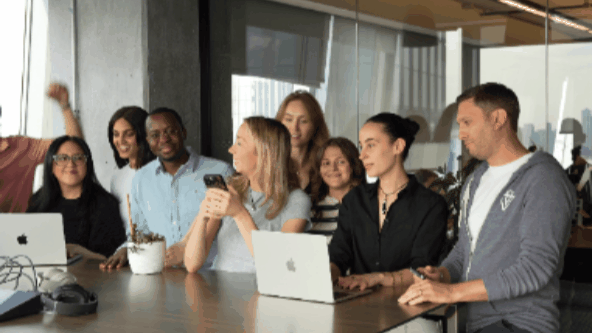 A team waving hello from inside the office that could build it themselves